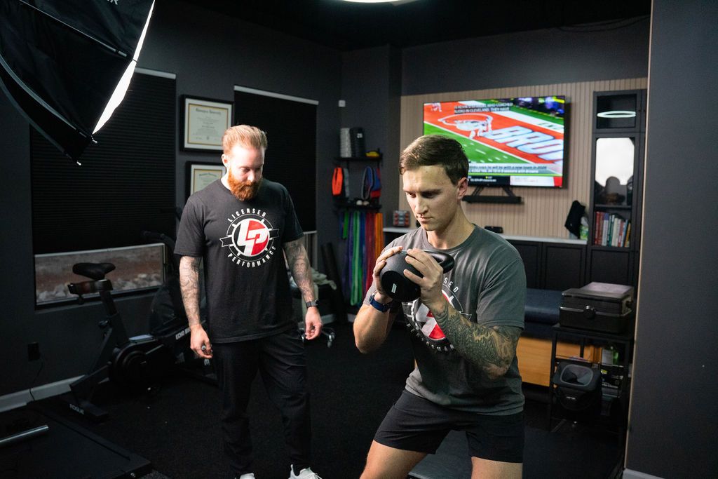 Youth athlete coached through a safe strength-training lift.
